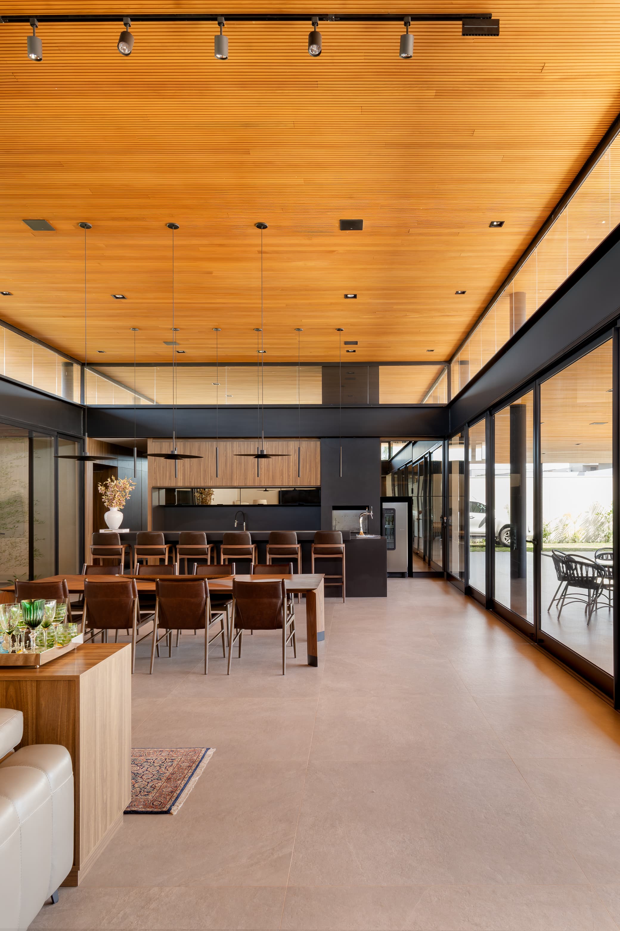 Casa LuSi – área gourmet com cozinha de bancada preta e abertura para jardim