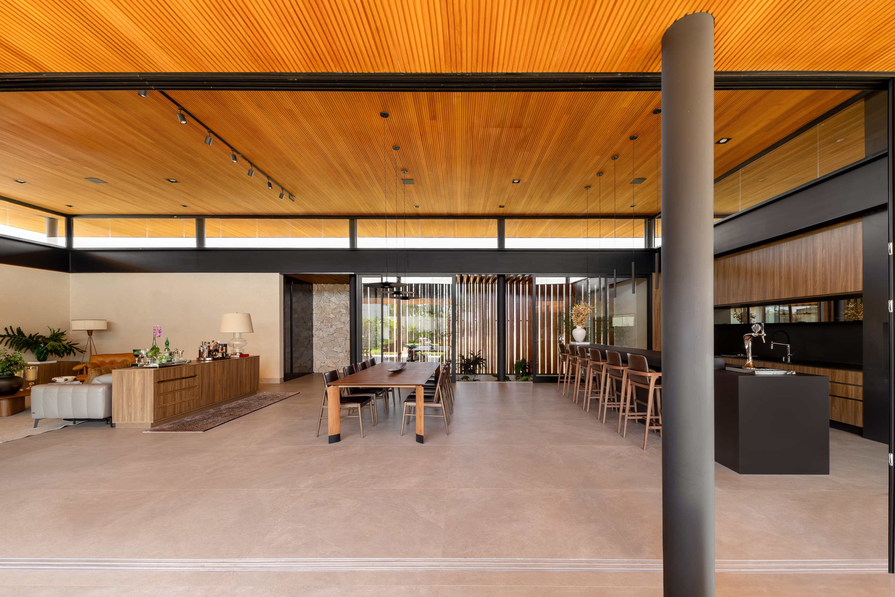 Casa LuSi – sala de jantar com teto em madeira e iluminação, integrada à cozinha