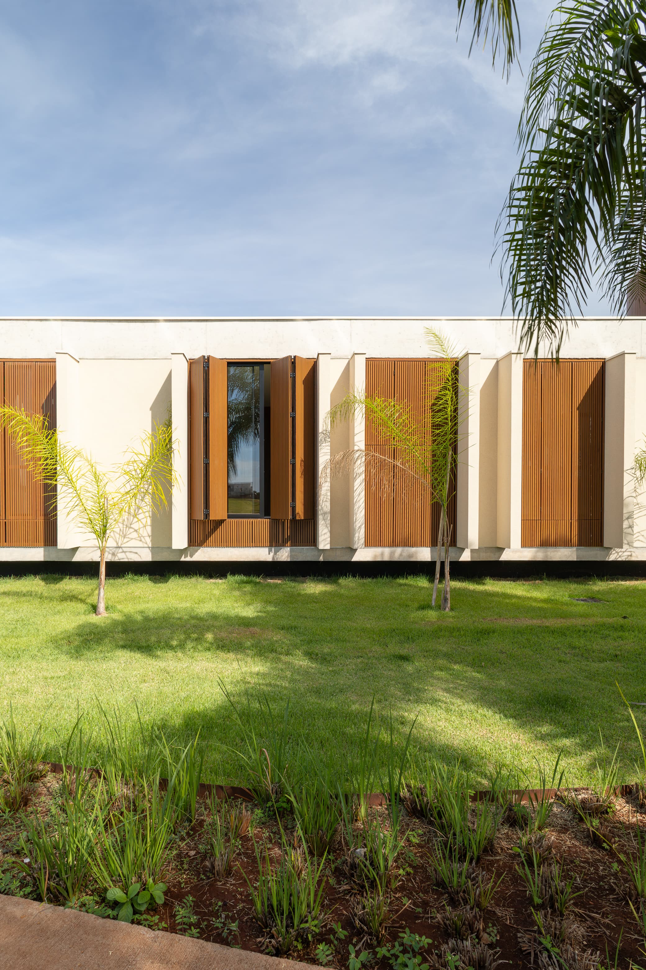Casa LuSi – detalhe da fachada com ripas de madeira e muro de pedra