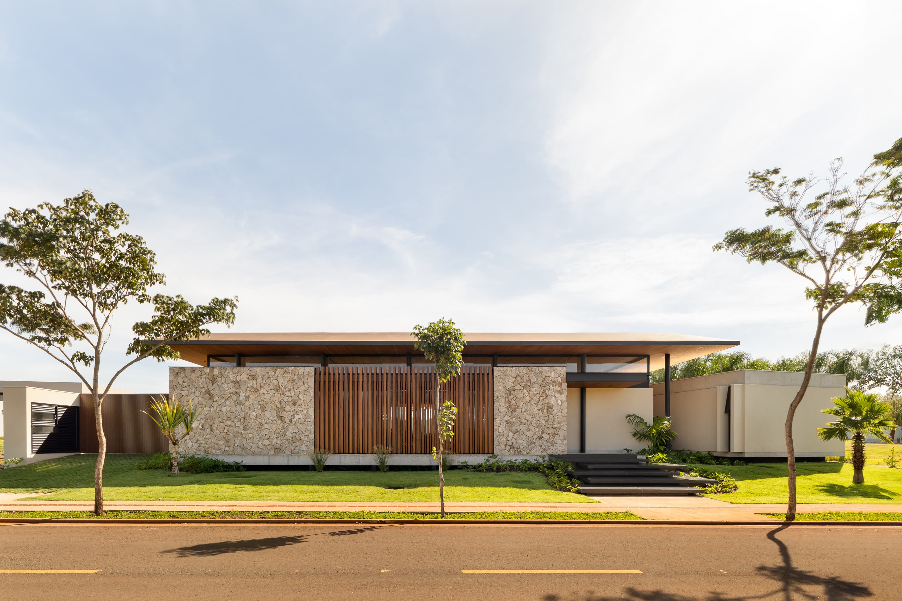 Casa LuSi – jardim frontal com paisagismo tropical e acesso principal