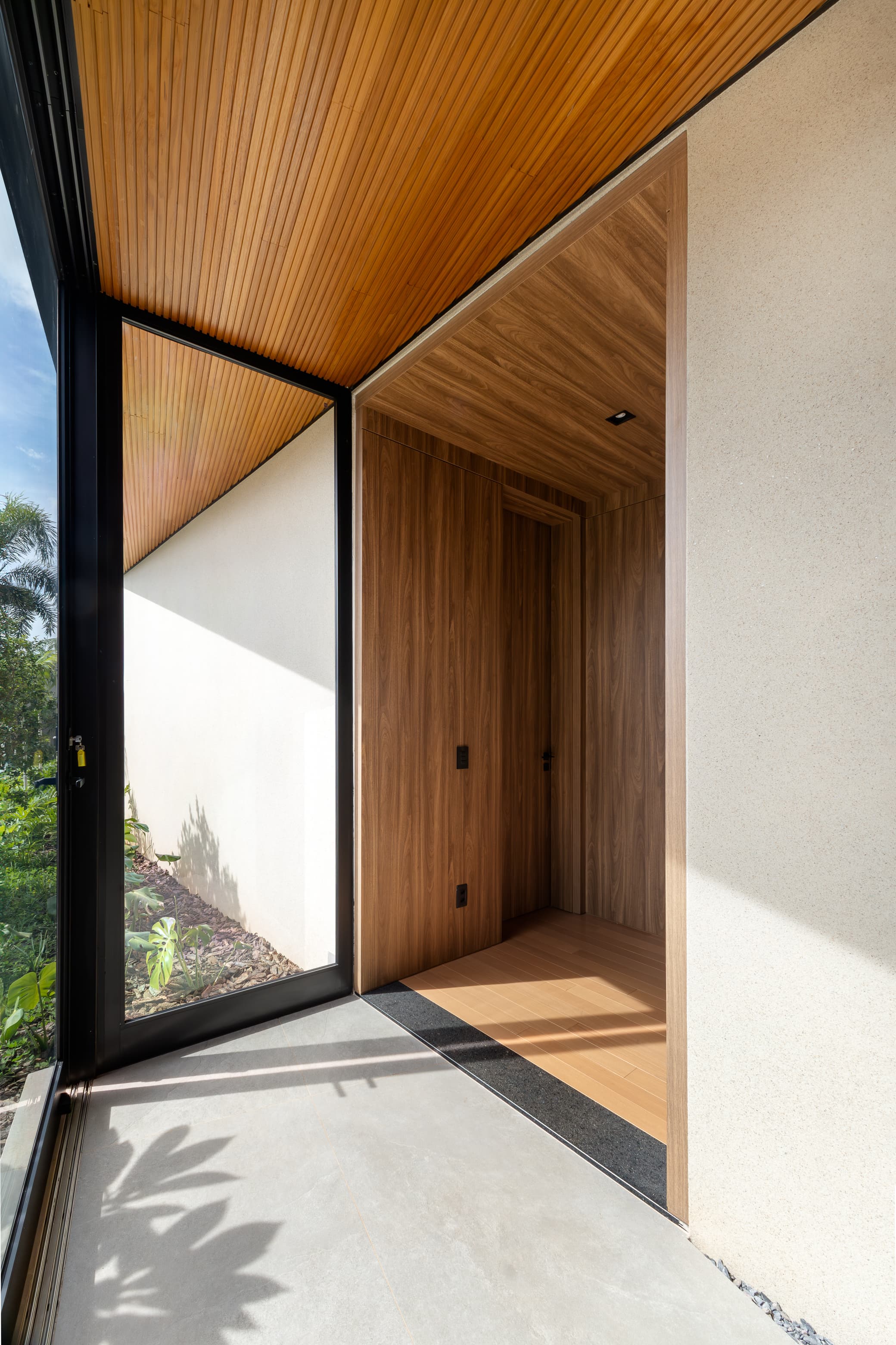 Casa LuSi – detalhes de texturas: porta de madeira, parede e pedra natural