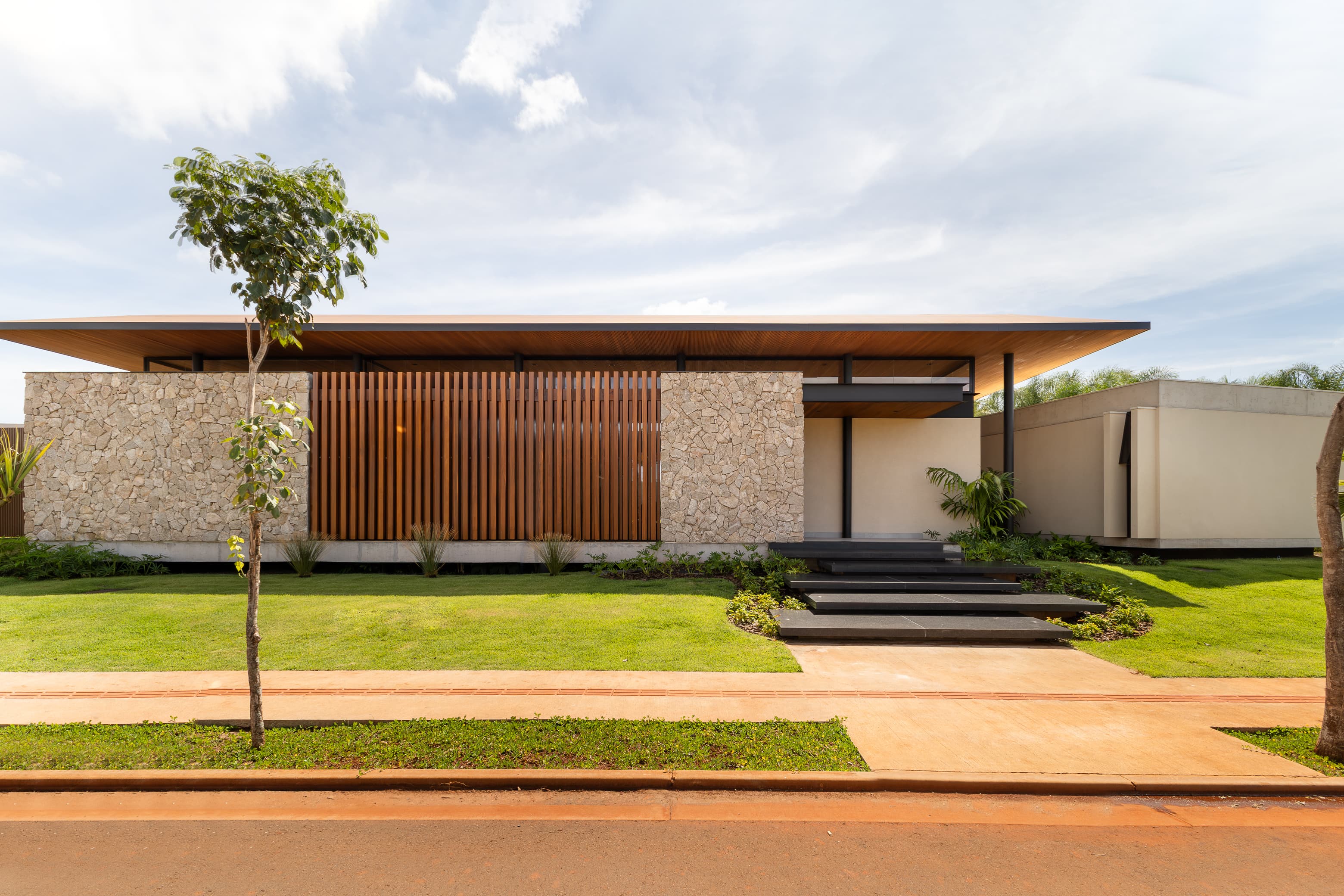 Casa LuSi – fachada principal da residência com jardim e palmeiras
