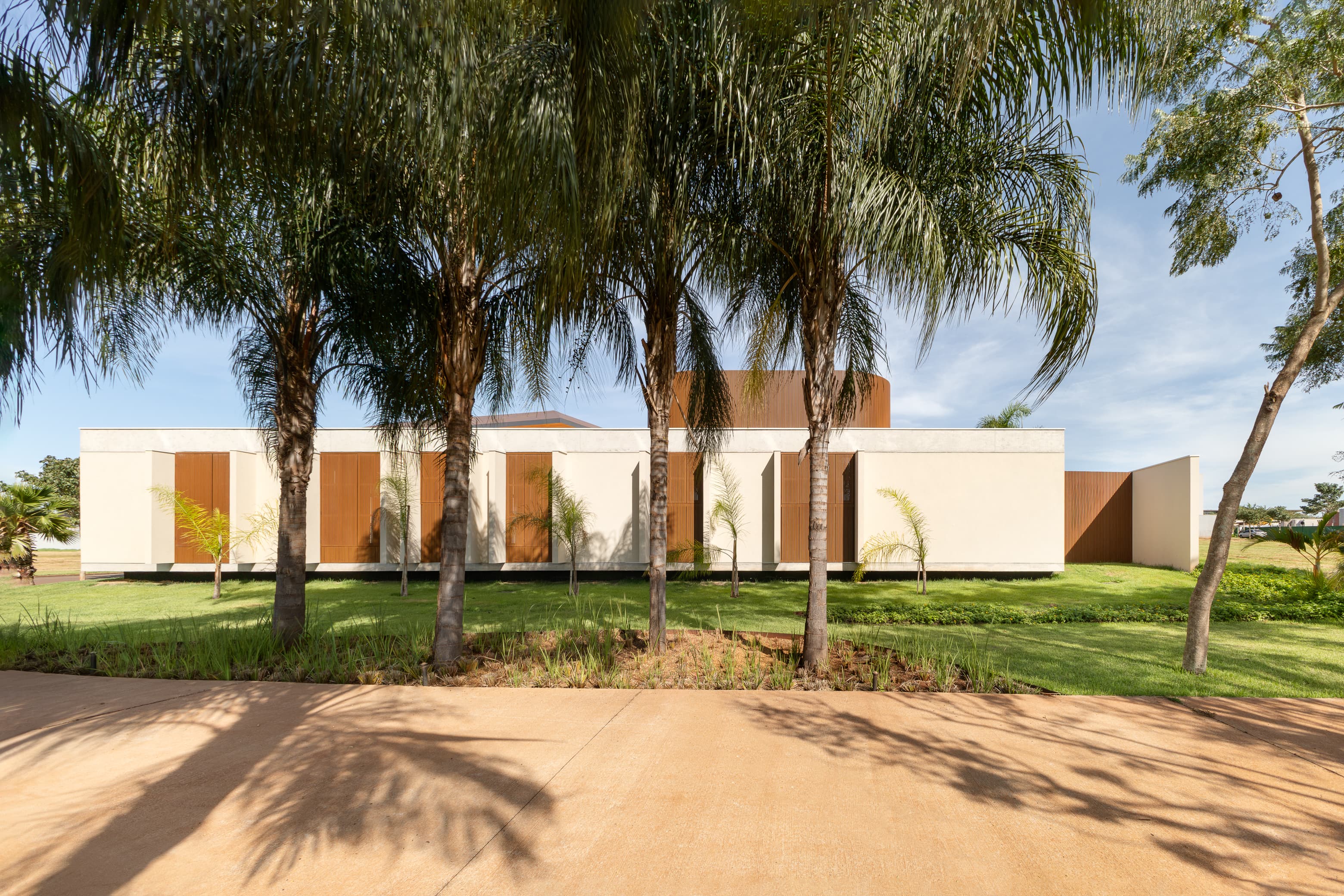 Casa LuSi – parede de pedra natural na fachada e jardim lateral