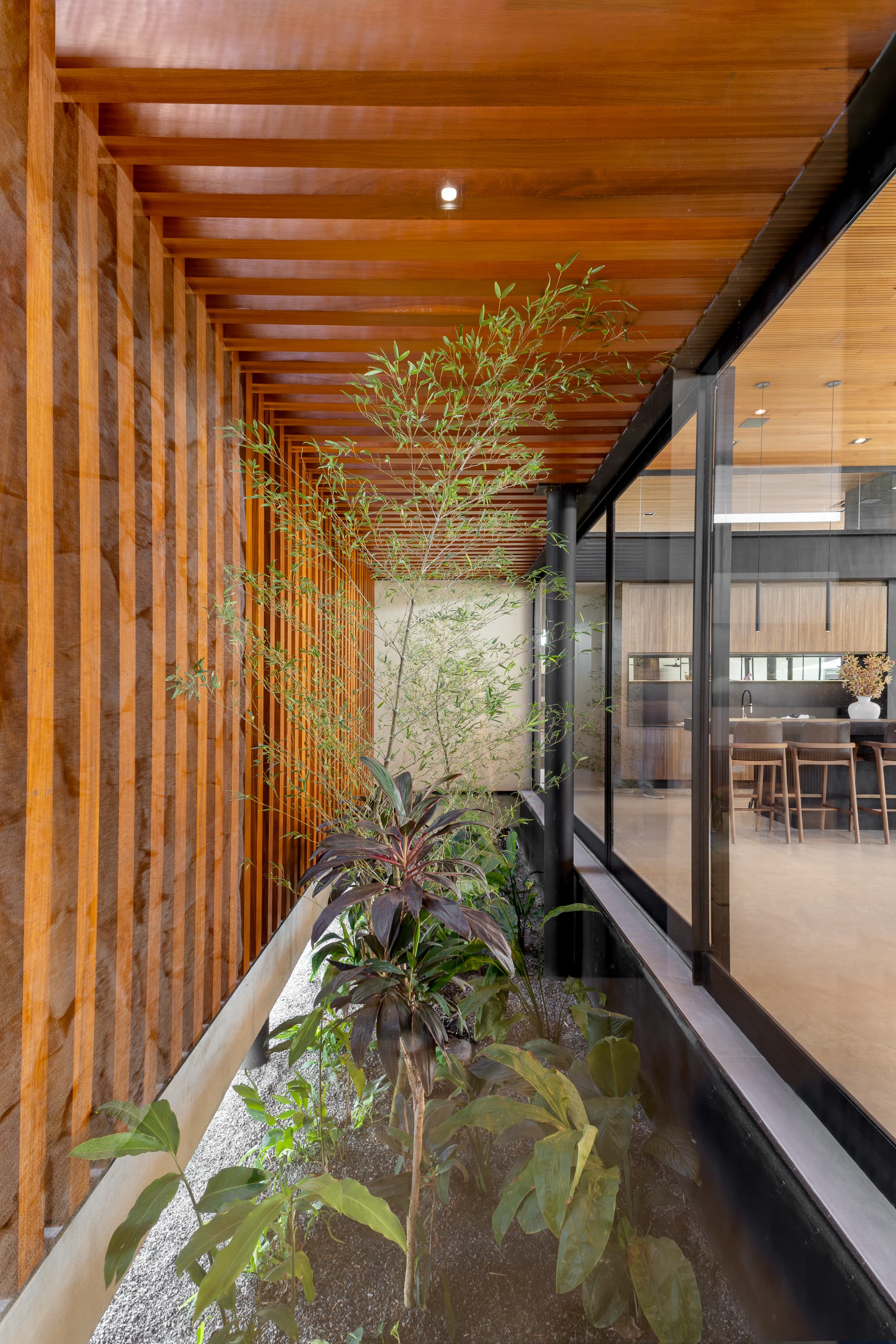 Casa LuSi – jardim vertical com bambus e ripas de madeira integrado à sala de jantar