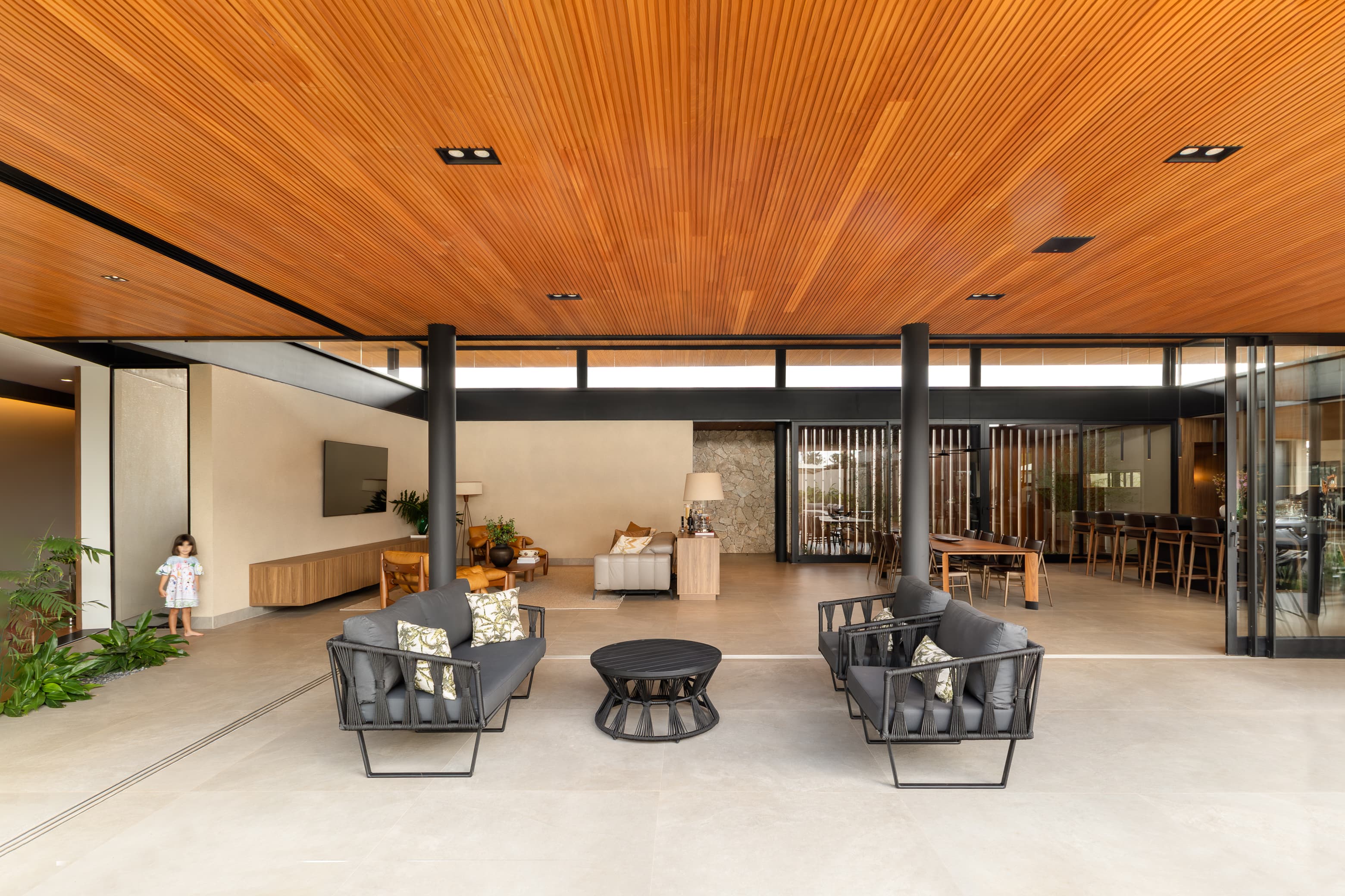 Casa LuSi – sala de estar com TV integrada à sala de jantar e teto em madeira
