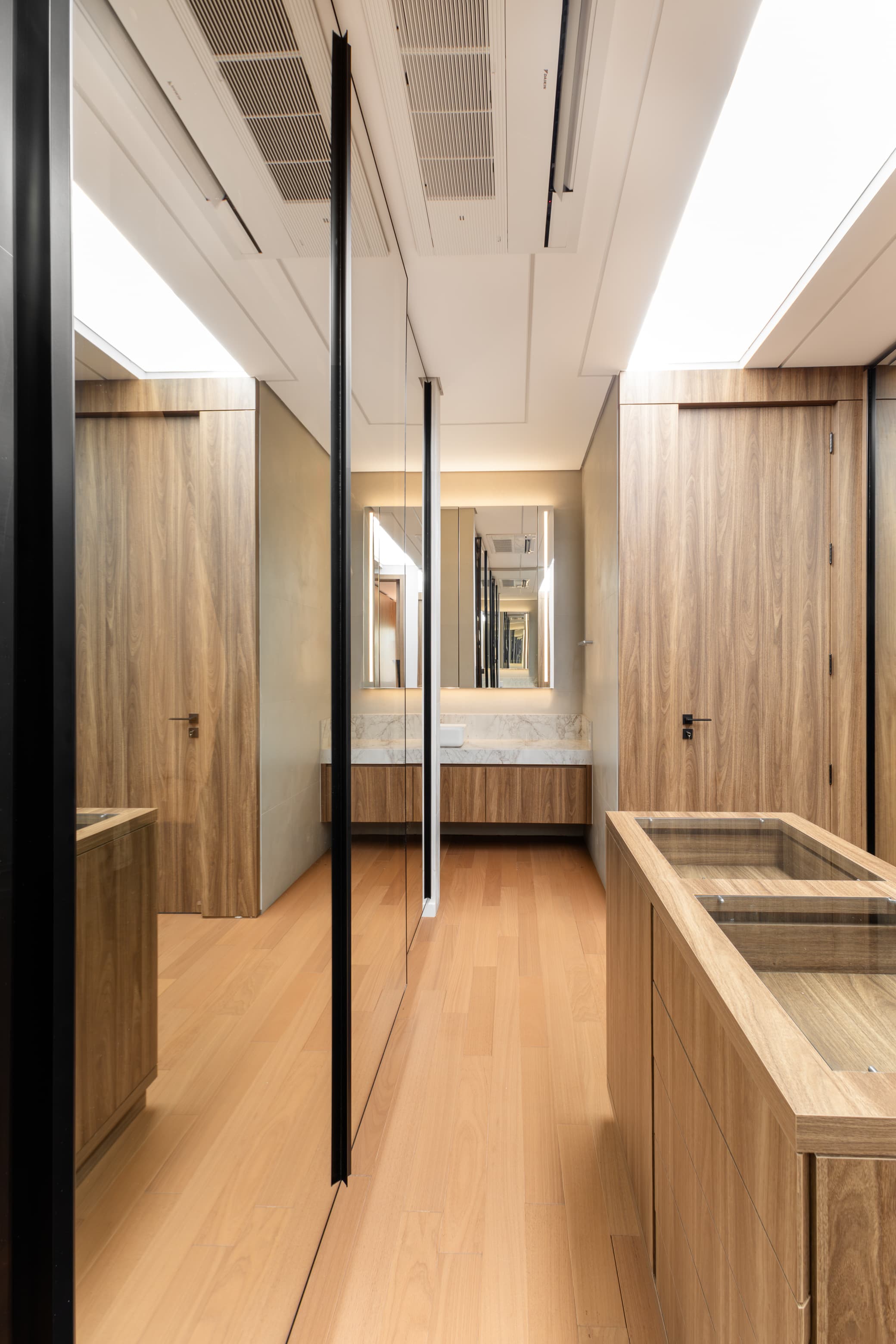 Casa LuSi – corredor interno com portas em madeira e piso claro